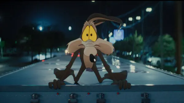 A scared Wile E. Coyote on top of a moving truck