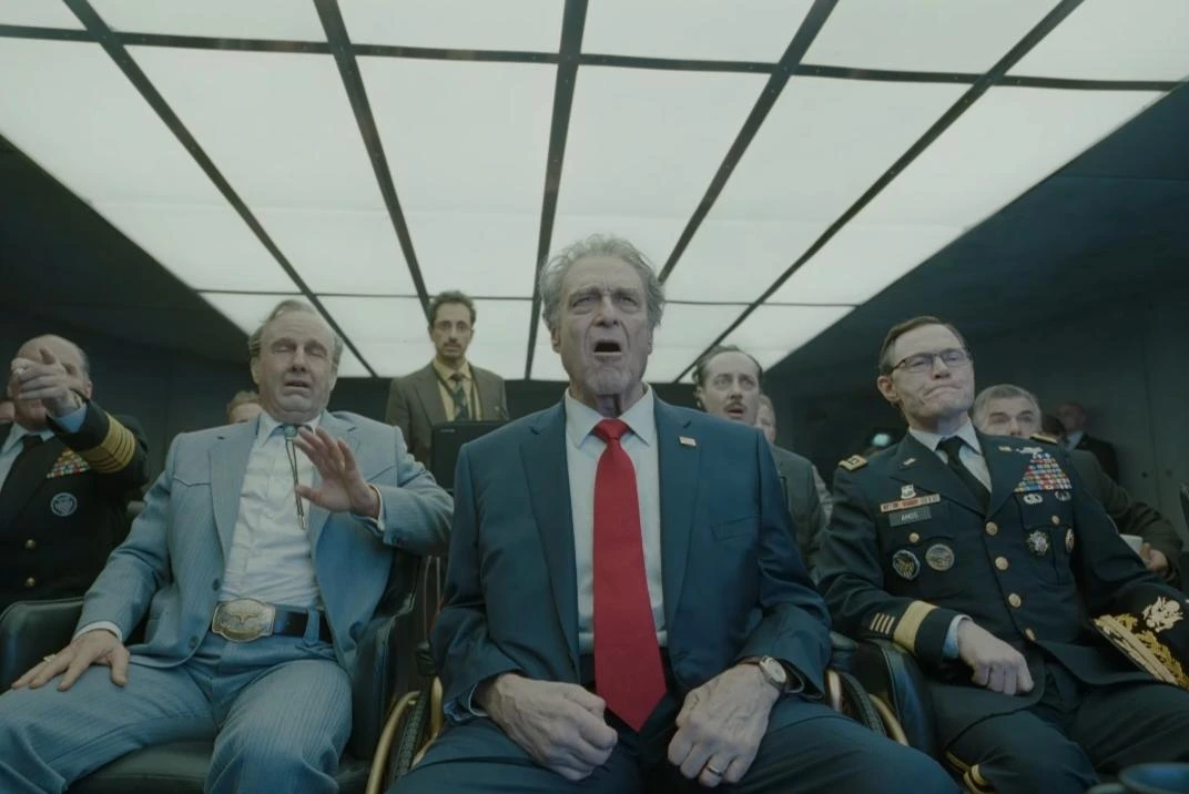 Rockwell and the president watching something with a group
