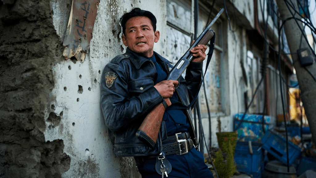 Go Bum-seok holding a gun with his back against a wall