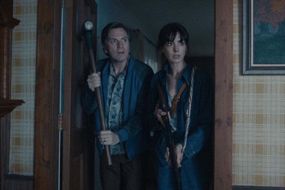 Greg and Denise holding weapons in a doorway