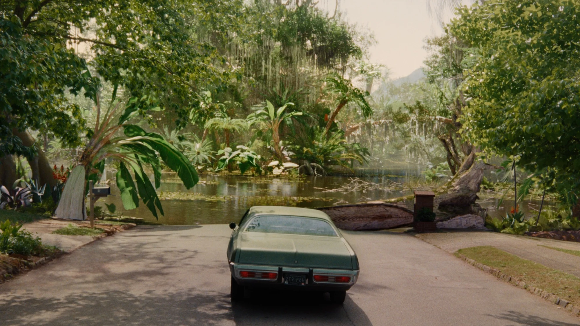 A car facing a road leading into a prehistoric landscape